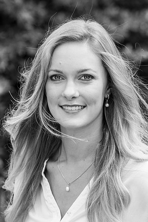 Outdoor headshot portrait of pretty girl with windswept hair