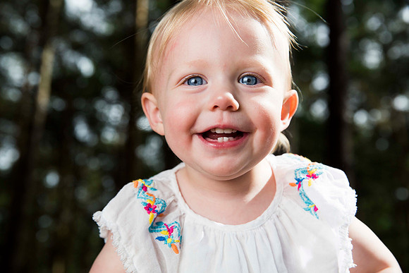 Portrait of baby girl with blue eyes in forest
