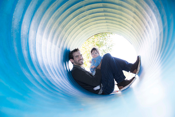 Portrait of father and daughter in blue tunnel in the park