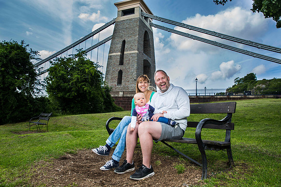 Family portrait on bench of mum dad baby daughter clifton suspension bridge bristol