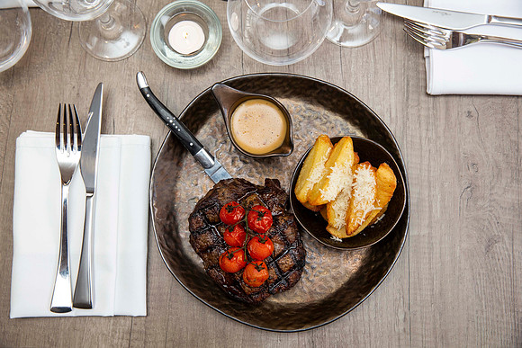 Steak peppercorn sauce and potato wedges food photography