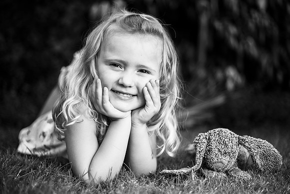 Portrait of cute girl with teddy bear in garden